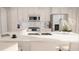 Bright white kitchen featuring stainless steel appliances and a breakfast bar with modern counter stools at 600 3Rd S Ave # 405, St Petersburg, FL 33701