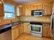 Kitchen with wood cabinets, granite counters, and stainless steel appliances at 820 Gulf Blvd # S 1-3, Indian Rocks Beach, FL 33785