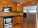 Kitchen with wood cabinets, granite counters, and stainless steel appliances at 820 Gulf Blvd # S 1-3, Indian Rocks Beach, FL 33785