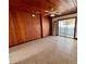 Living room with wood paneled walls, tile floors, and sliding doors at 820 Gulf Blvd # S 1-3, Indian Rocks Beach, FL 33785
