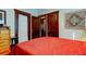 Spacious bedroom with red bedding, a dresser, and double doors at 115 Athens St, Tarpon Springs, FL 34689