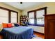 Cozy bedroom with a blue comforter, wooden dresser, and built-in shelving at 115 Athens St, Tarpon Springs, FL 34689