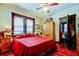 Comfortable bedroom with red bedding and a wooden armoire at 115 Athens St, Tarpon Springs, FL 34689
