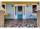 Quaint front porch featuring a mosaic tile floor and a bright blue door at 115 Athens St, Tarpon Springs, FL 34689