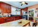Orange-walled kitchen with wood cabinets and a farmhouse table at 115 Athens St, Tarpon Springs, FL 34689