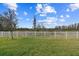 Green grassy backyard with a white fence at 19315 Hawk Valley Dr, Tampa, FL 33647