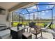Relaxing screened patio with wicker furniture, overlooking backyard at 19315 Hawk Valley Dr, Tampa, FL 33647