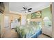 Bright bedroom with a queen bed, dresser, and ceiling fan at 19417 Gulf Blvd # C-211, Indian Shores, FL 33785