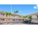 Exterior view of condo building with parking and tropical landscaping at 19417 Gulf Blvd # C-211, Indian Shores, FL 33785