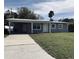 Ranch-style home with carport and well-maintained lawn at 5111 Eldorado Dr, Tampa, FL 33615