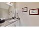 Elegant bathroom with granite countertop, mirror, and framed artwork at 5221 Wishing Arch Dr, Apollo Beach, FL 33572
