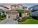 Two-story house with a light pink exterior, gray roof, and palm trees at 5221 Wishing Arch Dr, Apollo Beach, FL 33572