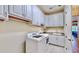 Bright laundry room with white cabinets, washer, dryer, and ample storage at 5221 Wishing Arch Dr, Apollo Beach, FL 33572