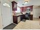 Well-lit kitchen featuring stainless steel appliances, dark cabinets, and mosaic backsplash at 7211 Waycross Ave, Tampa, FL 33619