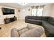 Inviting living room with tile floors, comfortable gray sofa and entertainment area at 7211 Waycross Ave, Tampa, FL 33619