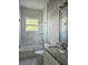 Elegant bathroom featuring granite vanity, shower over tub with glass screen and marble tile at 122 W Sligh Ave, Tampa, FL 33604
