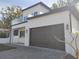 Two-story modern home with dark brown garage door and glass balcony at 122 W Sligh Ave, Tampa, FL 33604