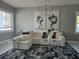 Bright living room featuring white sectional, black and white rug, and crystal chandelier at 122 W Sligh Ave, Tampa, FL 33604