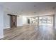 Spacious living room with wood-look tile floors and barn door at 12417 84Th Way, Largo, FL 33773