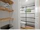 Modern bathroom featuring a sliding glass shower door, wood shelving, and updated fixtures at 15111 Verona Ave, Clearwater, FL 33760