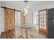 Bright dining area with glass table, wood floors, and barn door at 15111 Verona Ave, Clearwater, FL 33760