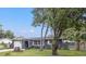 Newly renovated home with gray exterior, white garage door, and landscaped yard at 15111 Verona Ave, Clearwater, FL 33760
