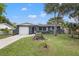 Gray house with a white garage door and well-maintained lawn at 15111 Verona Ave, Clearwater, FL 33760