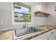Modern kitchen features stainless steel sink, wood countertops, and white cabinets at 15111 Verona Ave, Clearwater, FL 33760