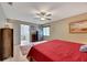 Main bedroom with king bed, red bedding, and ensuite bathroom at 1719 S Pebble Beach Blvd, Sun City Center, FL 33573