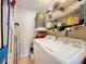Functional laundry room with washer, dryer, water heater and ample storage shelving at 2281 Lake Arbor Blvd, Clearwater, FL 33763