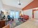 Cozy living room with a ceiling fan, sliding glass doors, and a pop of color from the accent wall and rug at 2281 Lake Arbor Blvd, Clearwater, FL 33763