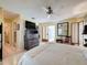 Bright main bedroom features a ceiling fan, ornate dresser, and access to the main bathroom at 2281 Lake Arbor Blvd, Clearwater, FL 33763