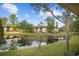 A view of the exterior and pond from the backyard, with a dock and a gazebo at 2679 Sabal Springs Cir # 203, Clearwater, FL 33761