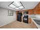Kitchen with wood cabinets, black appliances, and light flooring at 2679 Sabal Springs Cir # 203, Clearwater, FL 33761