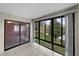 Sunroom boasts tiled flooring and expansive windows with views of the lush outdoor landscape and water at 2679 Sabal Springs Cir # 203, Clearwater, FL 33761