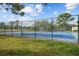 Community tennis court with blue surface, green fence, and well-maintained surrounding landscape at 2679 Sabal Springs Cir # 203, Clearwater, FL 33761