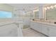 Elegant bathroom with double vanity, large shower, and soaking tub at 6510 Seabird Way, Apollo Beach, FL 33572