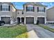 Daytime view of three-story townhouses with attached garages at 6912 Rock Springs Way, Tampa, FL 33625