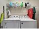 Bright laundry room with washer, dryer, and ample storage shelving at 6912 Rock Springs Way, Tampa, FL 33625