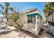 Side view of a yellow cottage with white picket fence and landscaping at 822 Gulf Blvd # 4-6, Indian Rocks Beach, FL 33785