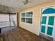 Screened porch with wood floor and teal door at 822 Gulf Blvd # 4-6, Indian Rocks Beach, FL 33785
