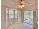 Bright breakfast nook with bay windows, ceiling fan, and sliding glass doors to the outdoor area at 9336 Villa Entrada, New Port Richey, FL 34655
