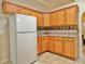 Corner kitchen with ample wood cabinets and white appliances at 9336 Villa Entrada, New Port Richey, FL 34655