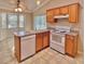 Kitchen with wood cabinets, white appliances, and a breakfast bar at 9336 Villa Entrada, New Port Richey, FL 34655