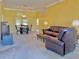 Spacious living room features a leather sofa and a view into the dining area at 9336 Villa Entrada, New Port Richey, FL 34655