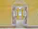 View through decorative glass doors into another room in the yellow interior home at 9336 Villa Entrada, New Port Richey, FL 34655