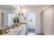 Double vanity bathroom with a shower and window at 18129 Canopy Pl, Lakewood Ranch, FL 34211