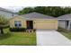 One-story house with yellow exterior, landscaping, and a two-car garage at 18292 Hunters Meadow Walk, Land O Lakes, FL 34638