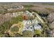An aerial view of a neighborhood surrounded by lush trees and a tranquil pond at 3203 Audubon Ct, Tarpon Springs, FL 34688