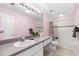 Bathroom features a large mirror with vanity lighting, shower over tub with tiled walls, and tile flooring at 3203 Audubon Ct, Tarpon Springs, FL 34688